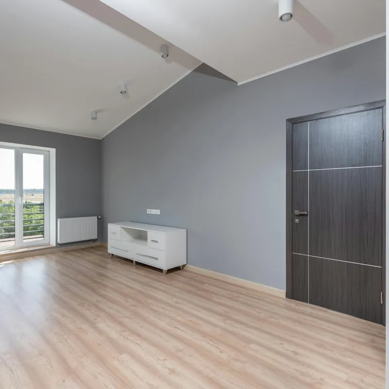 Wohnung mit Holzboden, grauen Wänden und weisser Kommode